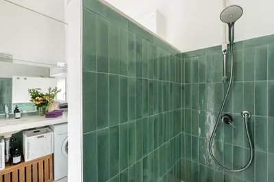 a bathroom with a shower with green tiles at Menta luxury apartment Rome in Rome