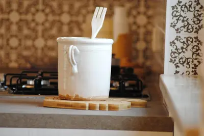 a white cup with a fork in it on a counter at Trullo Amato with exclusive pool in Rome