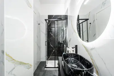 a bathroom with a black tub and a mirror at Centocinque Aparthouse - Luxe in Rome
