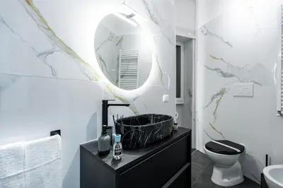a bathroom with a sink and a mirror on a cabinet at Centocinque Aparthouse - Luxe in Rome