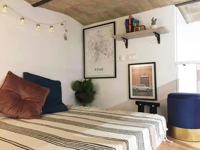 a bedroom with a bed with a striped blanket at Bright and cosy appartament near the city center in Rome
