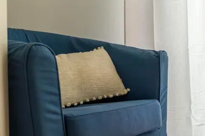 a blue couch with a brown pillow on it at iFlat Vatican Comfortable & Peaceful Retreat in Rome