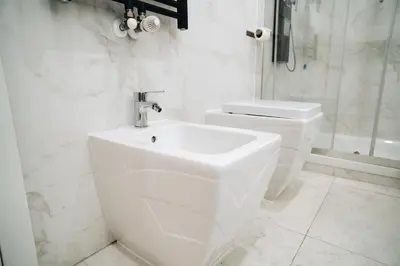 a white bathroom with a sink and a toilet at Escape Suite Guest House - Ca Domus Collection in Rome