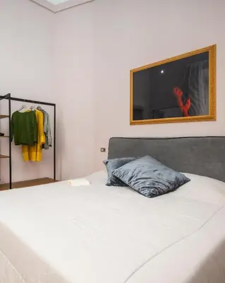 a bedroom with a bed with a television on the wall at Luxury house Empire 96 in Rome