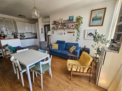 a living room with a table and a blue couch at Luminoso attico con terrazza in Rome