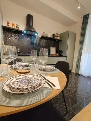 a wooden table with plates and wine glasses on it at Bellissimo bilocale al centro di Roma - Daniele Case Vacanza in Rome