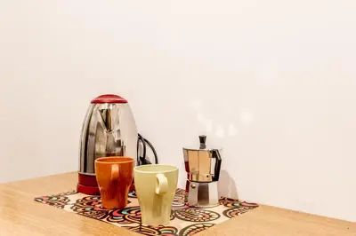 a table with affeepot and cups on a table at Elegant flat in front of Vatican museum in Rome