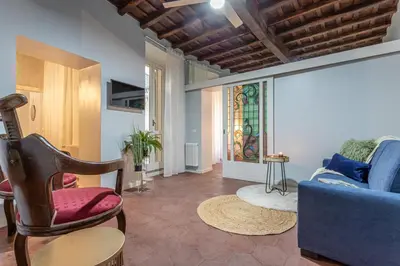 a living room with a blue couch and a stained glass window at Ambra - Liberty Apartment at the Imperial Forums in Rome