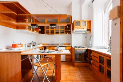 a kitchen with wooden cabinets and a table with chairs at Grande appartamento a Trastevere in Rome
