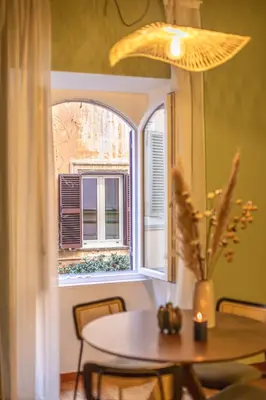 a table in front of a window with a table and a candle at Giada - Charming Apartment at the Imperial Forums in Rome