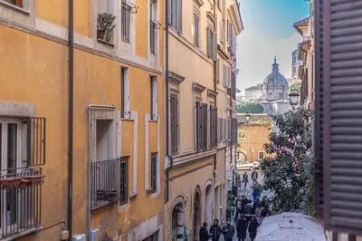a group of people walking down a street between buildings at Giada - Charming Apartment at the Imperial Forums in Rome