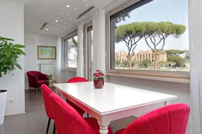 a dining room with a white table and red chairs at YCH-Exclusive apartment on Circus Maximus in Rome