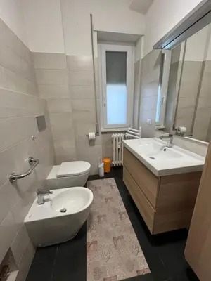 a bathroom with two sinks and a toilet and a mirror at Casa Conca D Oro in Rome