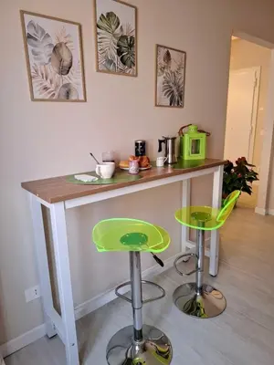 a kitchen with a counter and two green stools at Appartamento Aurelio in Rome