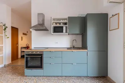 a kitchen with blue cabinets and a microwave at Grazioso appartamento a Roma San Paolo in Rome