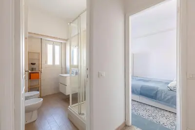 a bathroom with a toilet and a bed and a mirror at Grazioso appartamento a Roma San Paolo in Rome