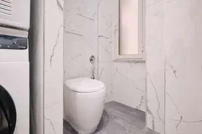 a white bathroom with a toilet and a mirror at Elegante appartamento a pochi passi dal Centro in Rome