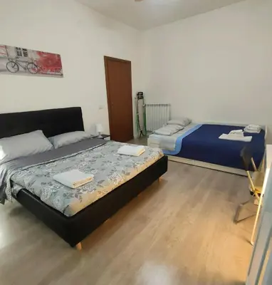 a bedroom with two beds and a chair in it at Casa Flegrei in Rome