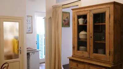a kitchen with a wooden cabinet with dishes in it at Cozy artsy apt near the Vatican in Rome