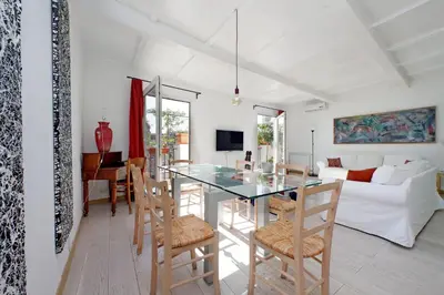 a dining room and living room with a glass table and chairs at Colosseo Attico Particolare Terrazza Panoramica in Rome
