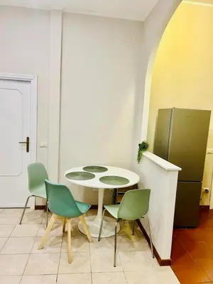 a kitchen with a table and chairs and a refrigerator at Fast Re Apartment in Rome
