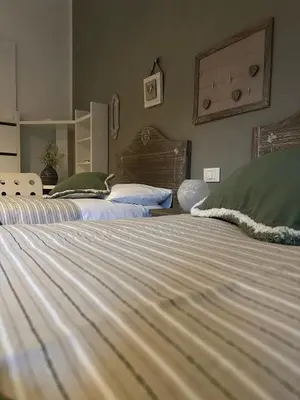 two beds with green and white sheets in a bedroom at A casa di Lù in Rome