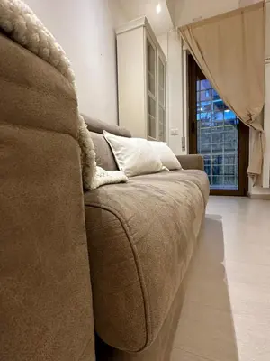 a brown couch in a living room with a window at A casa di Lù in Rome