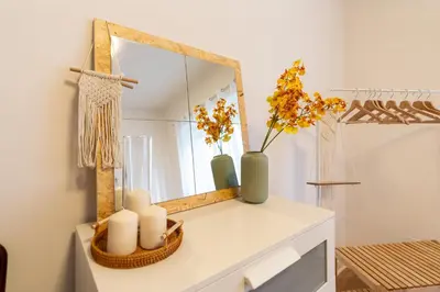 a mirror on top of a dresser with candles and flowers at Gemelli Apartment in Rome