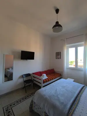 a bedroom with a bed and a couch and a window at Cozy Room in Rome