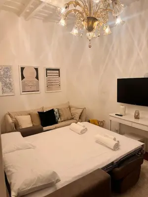 a large bed in a living room with a chandelier at Casa Roma in Rome