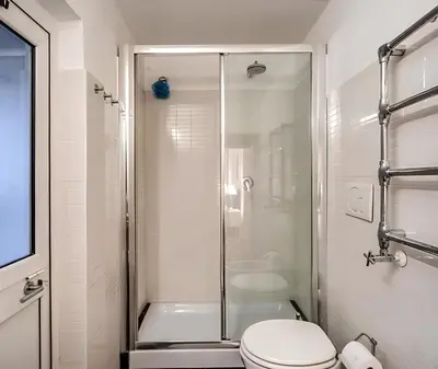 a white bathroom with a shower and a toilet at Casa Roma in Rome