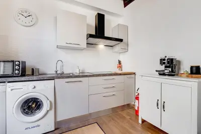 a kitchen with white cabinets and a washer and dryer at 5 min Piazza Navona-Aria Condizionata-Smart TV-Cucina completa in Rome