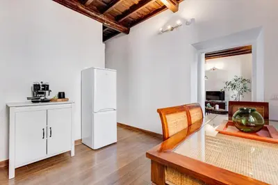 a kitchen with a white refrigerator and a table at 5 min Piazza Navona-Aria Condizionata-Smart TV-Cucina completa in Rome