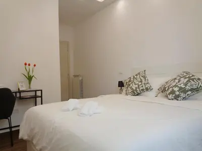 a white bed with two towels on top of it at Jumbo Inn in Rome