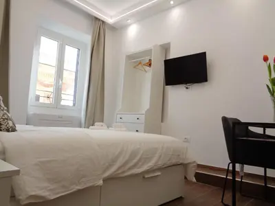 a bedroom with a bed and a tv on the wall at Jumbo Inn in Rome