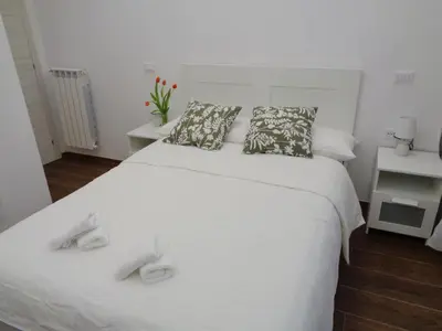 a white bed with two pillows on top of it at Jumbo Inn in Rome