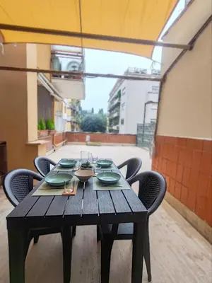 a wooden table with plates and wine glasses on it at Via Lattea Vatican Apartment - Family friendly in Rome
