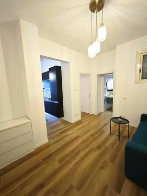 a living room with a blue couch and wooden floors at DOMUS Villa Chigi in Rome