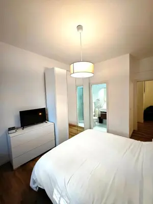 a bedroom with a white bed and a flat screen tv at DOMUS Villa Chigi in Rome