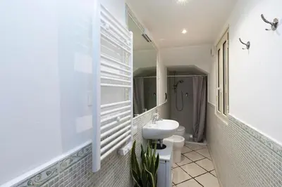 a white bathroom with a sink and a toilet at San Pietro Terrace Apartment in Rome