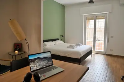 a room with a bed and a laptop on a desk at Appiano Garden Apartment in Rome