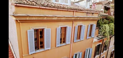 an orange building with blue shutters on it at Exclusive Flat Piazza di Spagna in Rome