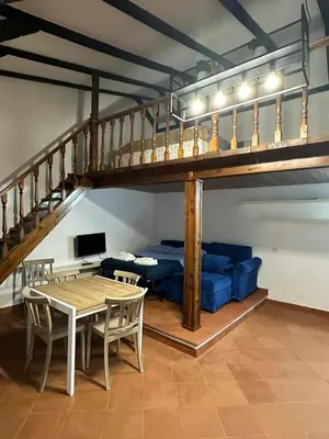 a living room with a loft bed and a table at EXCLUSIVE House OTTAVIANO in Rome