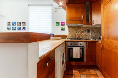 a kitchen with wooden cabinets and a stove top oven at Daniele Flat - Ospedale Gemelli - Metro Battistini in Rome