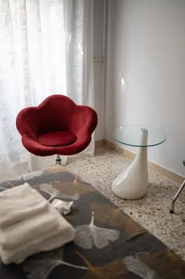 a red chair and a glass table in a room at La casa di Gegè Appio Caffarella in Rome