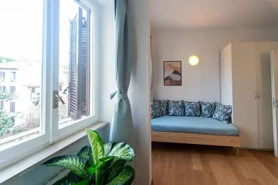 a living room with a couch and a large window at 4 Cantoni, cosy apartment in Monti District in Rome