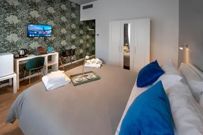 a bedroom with a large white bed with blue pillows at Guest House VB Luxury Suites in Rome