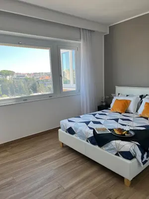 a bedroom with a bed with a tray of food on it at Attico Vacanza Roma Nord - Casa Mengotti in Rome