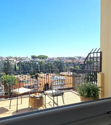 a balcony with chairs and a view of a city at Attico Vacanza Roma Nord - Casa Mengotti in Rome