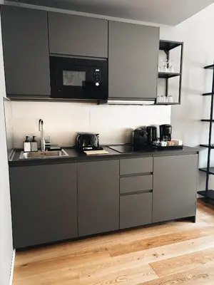 a kitchen with black cabinets and a sink and a microwave at Twentythree Luxury Apartment in Rome